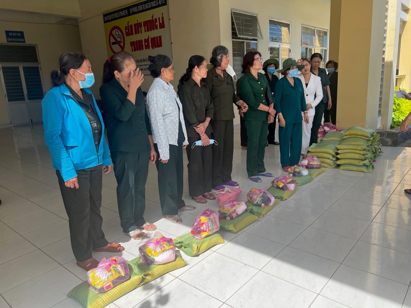 Người dân xếp hàng bên phần quà gạo và nhu yếu phẩm do BECO tài trợ